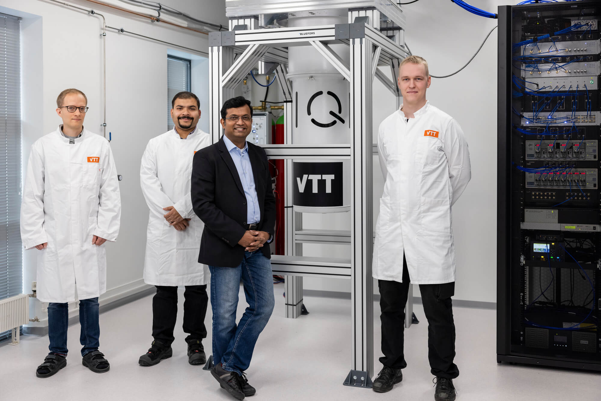 Finnish scientists stand in front of Finland’s first commerical 54-qubit quantum computer.