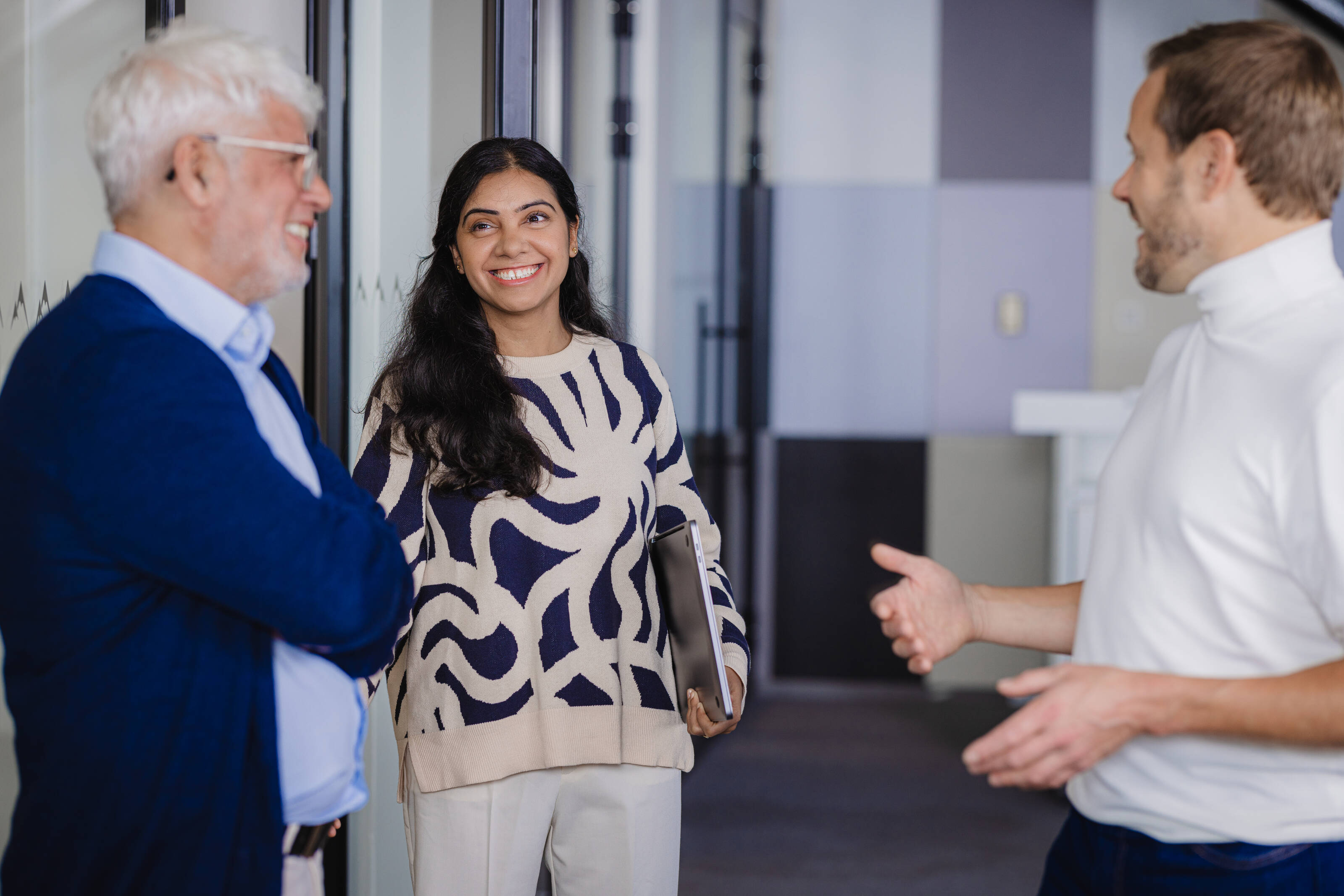 Two men and woman talking at the office